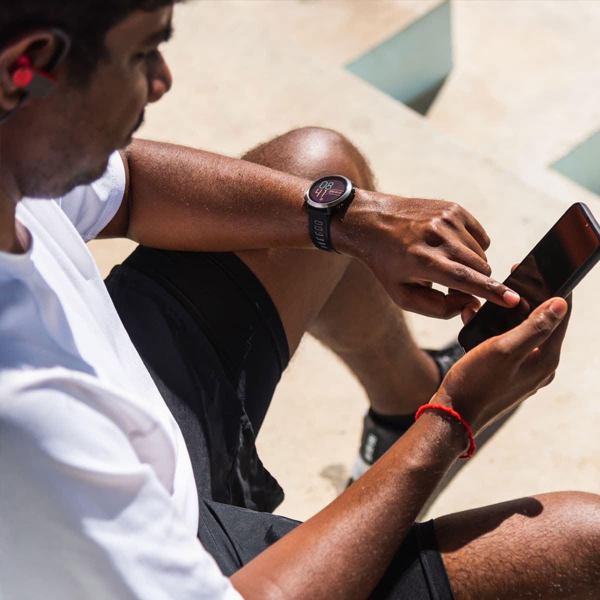 smartphone innovation 2026 person using smartphone with smartwatch and earbuds outdoor lifestyle
