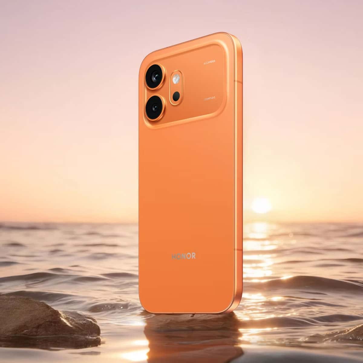 Honor 600 Vitality smartphone in orange standing in shallow water at sunset, highlighting its sleek design and dual rear cameras.