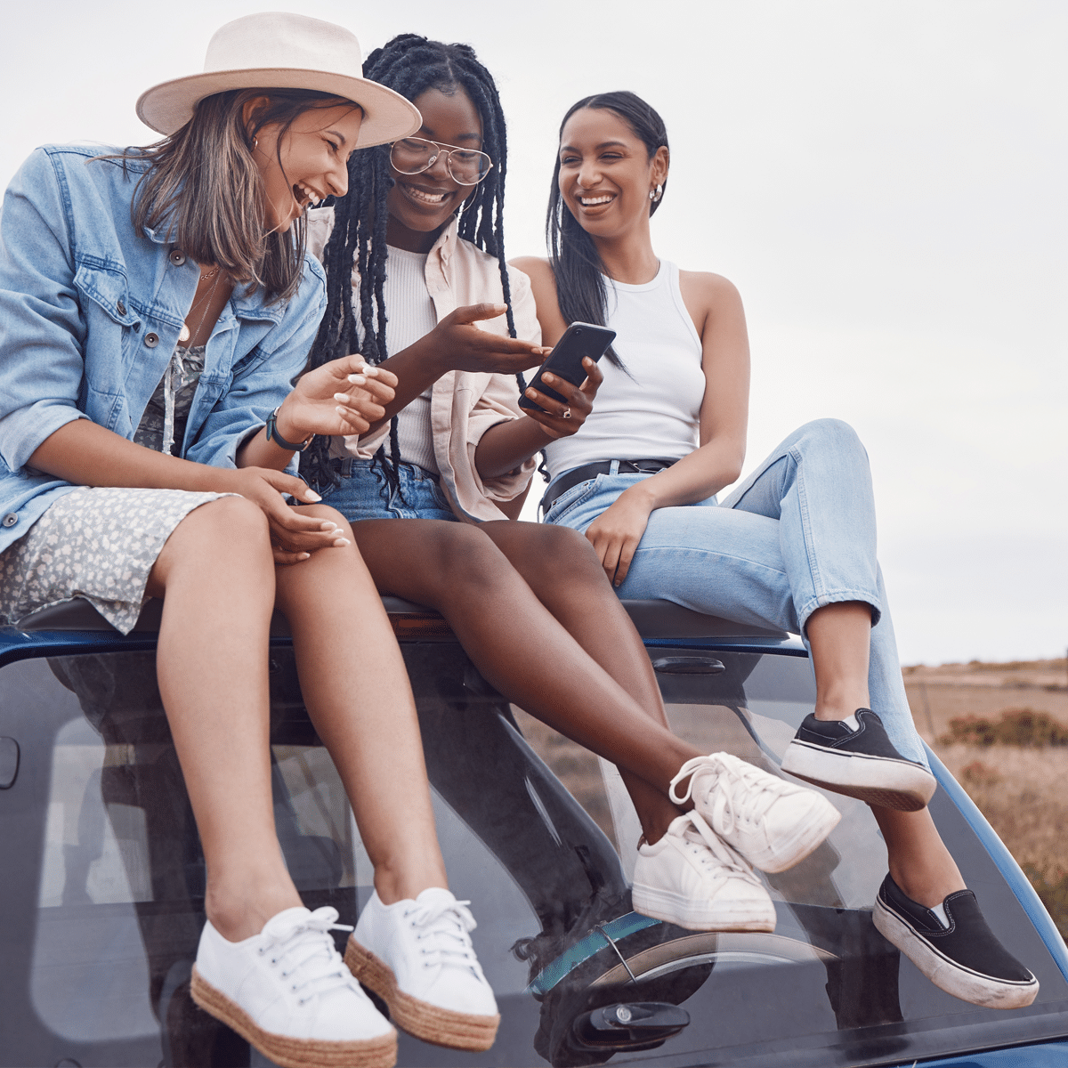 5G in South Africa remains underused despite the country’s fast networks, as three friends use a smartphone while travelling.