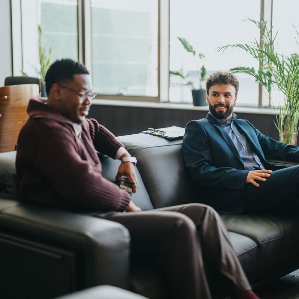Two business professionals having a relaxed conversation in a modern office.